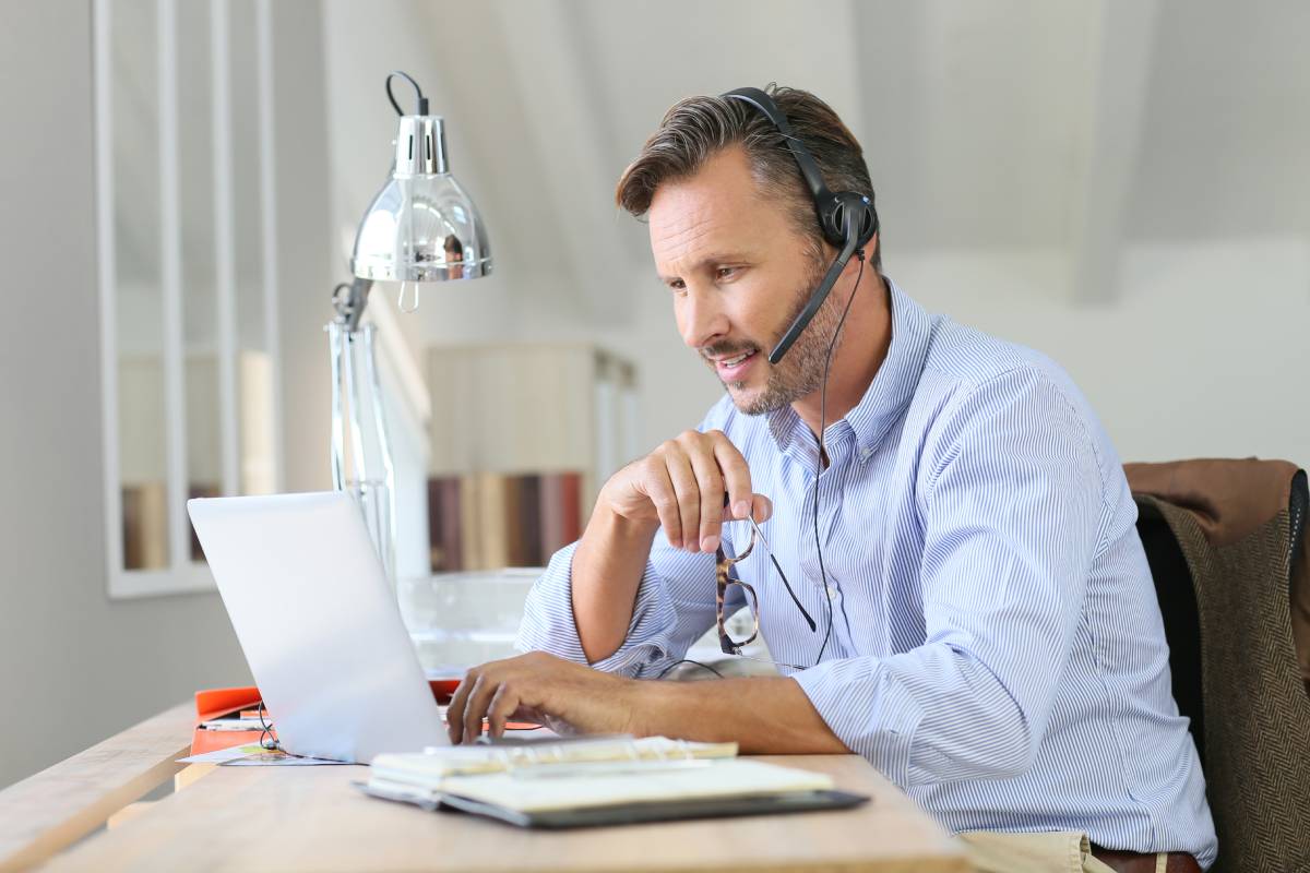 A businessman working from home using a headset