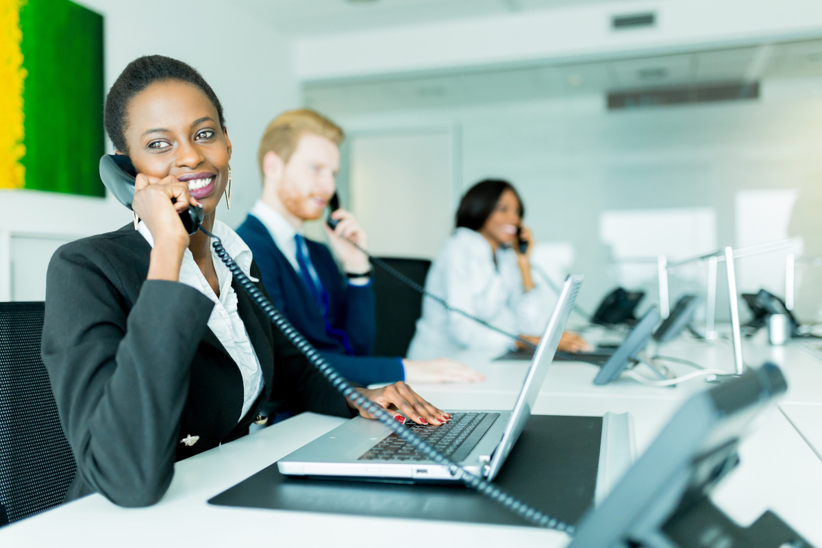 A group of employees each on their respective office phone