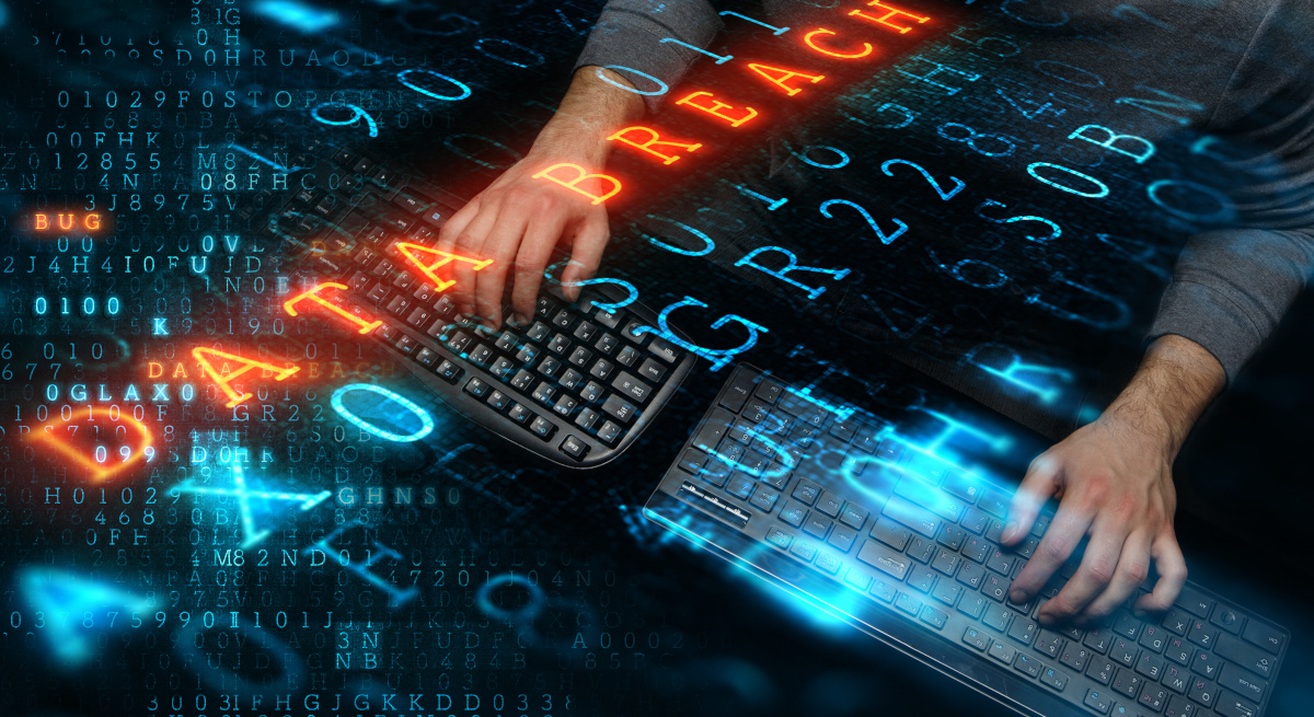 Man typing on keyboard with words Data Breach floating above it