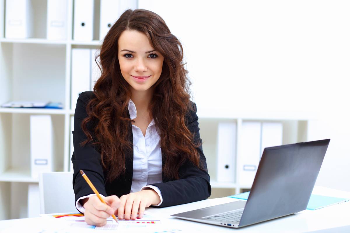 A business woman smiling while working on her laptop