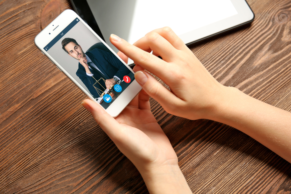 Someone video conferencing with a lawyer on the phone through unified communications.