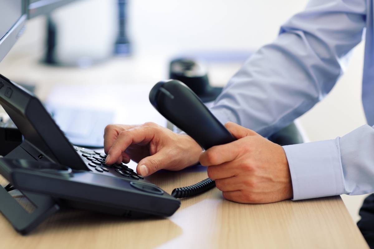 A businessman dialing a number on a business phone