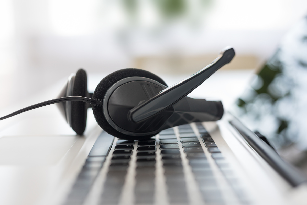 A phone headset resting on an open laptop