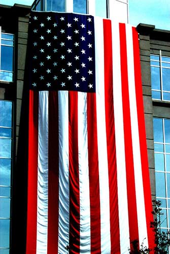 High Contrast American Flag Hanging from Stone and Glass Building